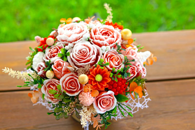 Oranži-sarkans ziepju ziedu pušķis ar zelta akcentiem no rozēm, tulpēm un peonijām